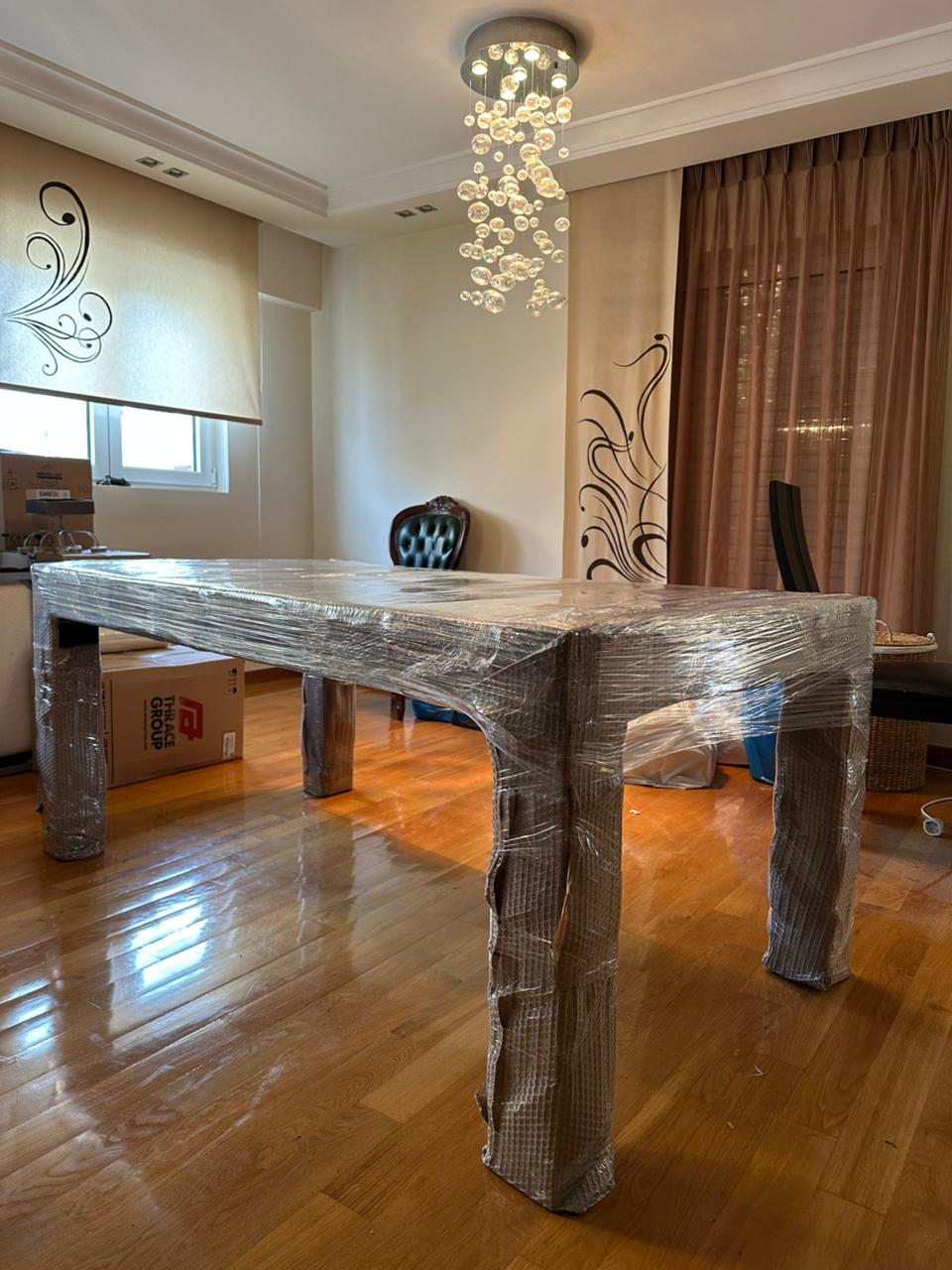 Έπιπλα τυλιγμένα με αμπαλάζ μέσα σε σπίτι πριν τη μετακόμιση